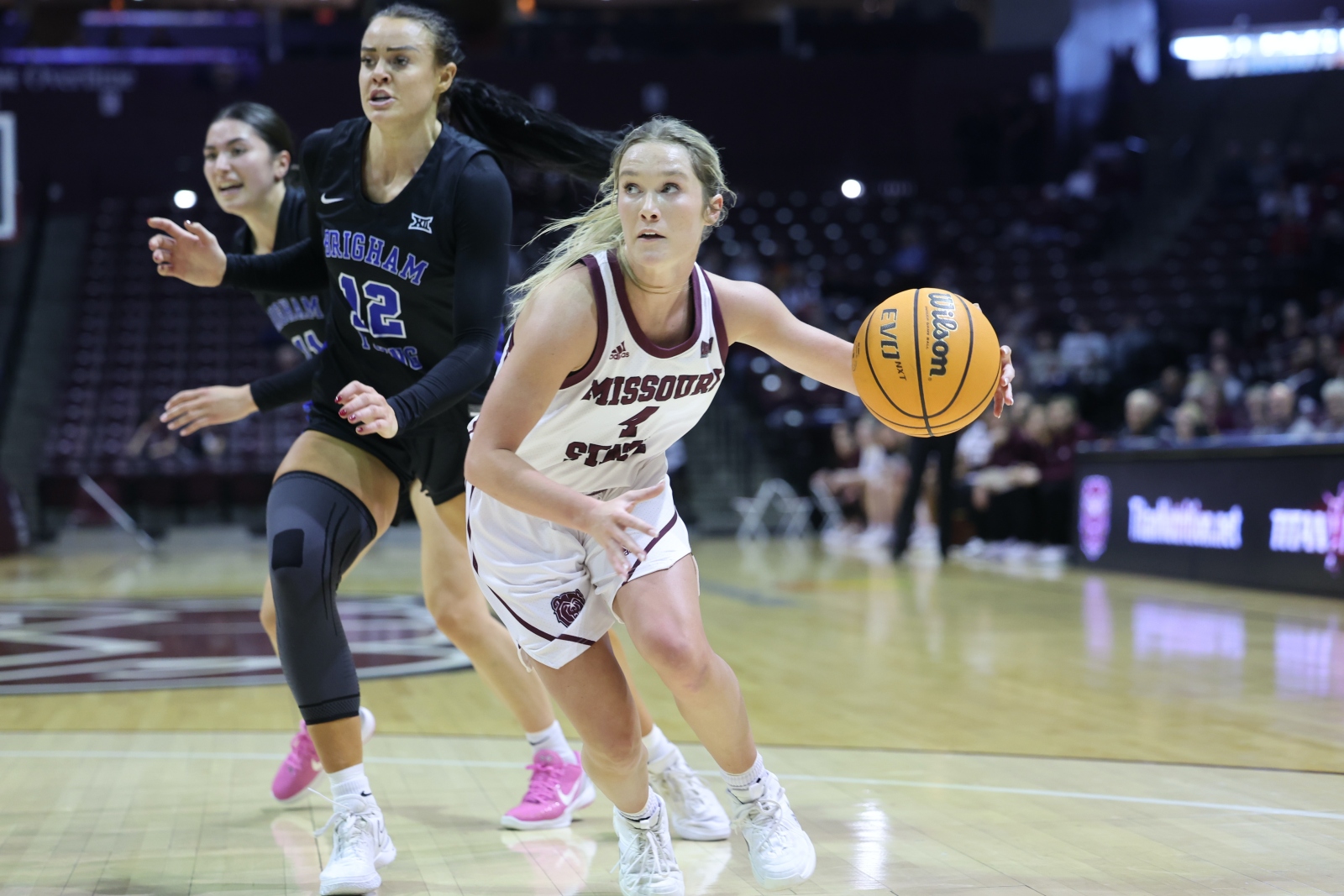 Lacy Stokes, wearing a Missouri State Lady Bears uniform, dribbles toward the basket during a game at Great Southern Bank Arena in Springfield, Missouri.