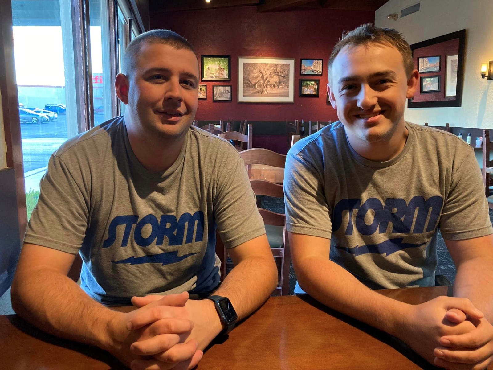 Brothers Blake Demore and Spencer Robarge sit side by side in matching gray T-shirts with the word "Storm" printed on them in blue.