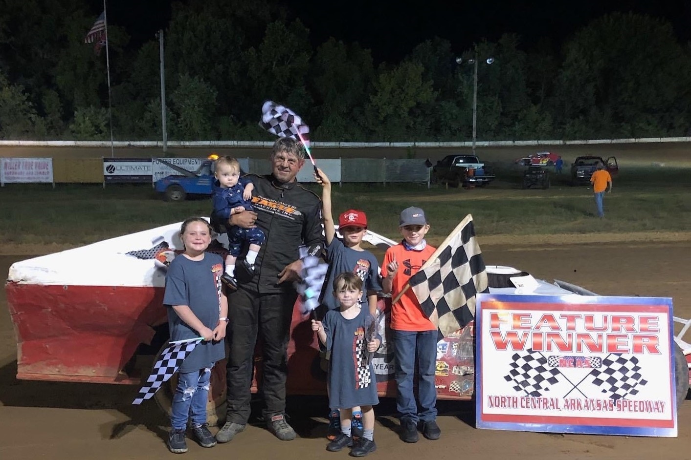 Stephen Muilenburg poses with his grandchildren and his race car after winning his 800th career race.