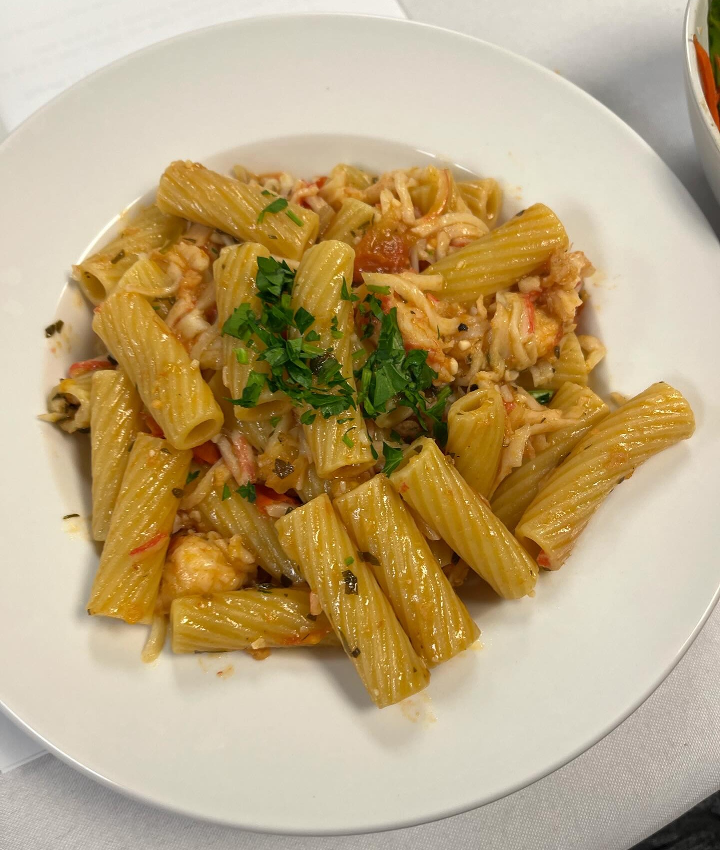 A pasta dish is served on a white plate.