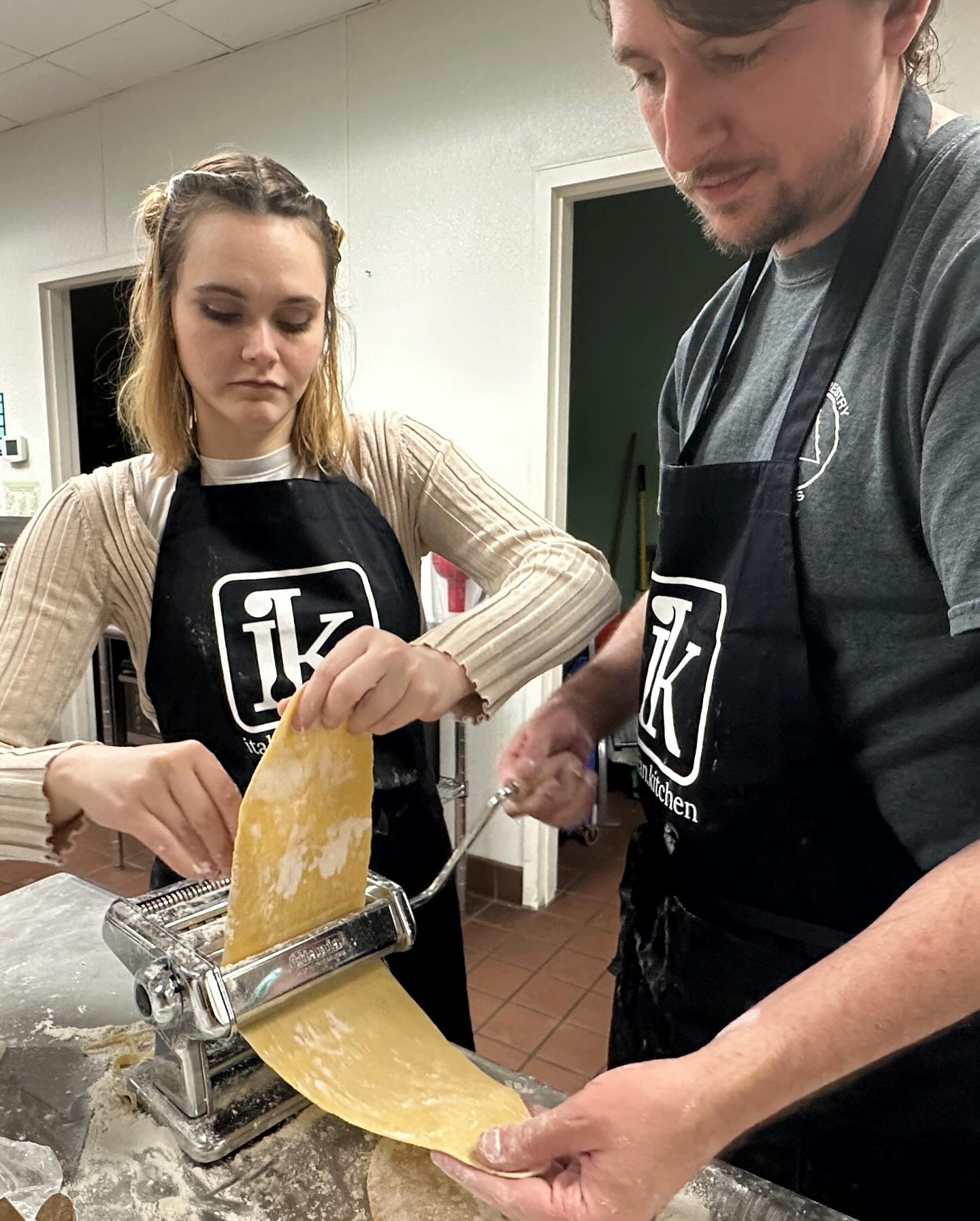 A man and a woman use a pasta maker during a cooking class at Italian Kitchen in Springfield, Missouri