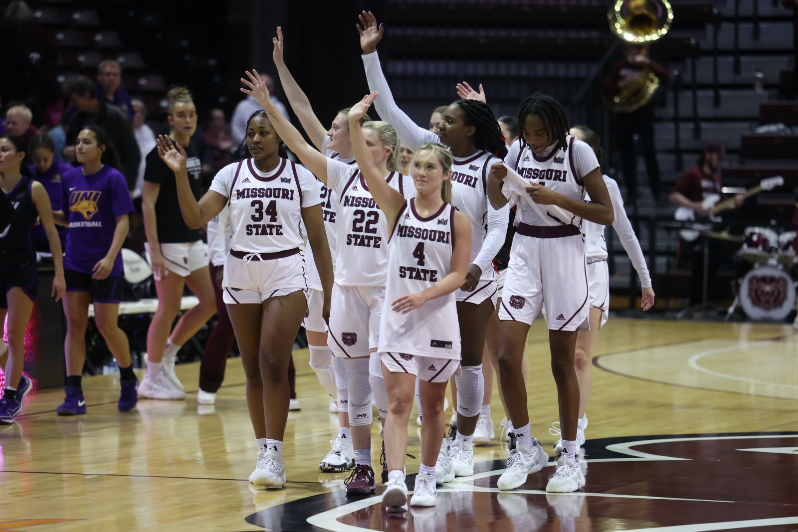 The Missouri State Lady Bears wave to the crowd as they walk off the court after a basketball game at Great Southern Bank Arena