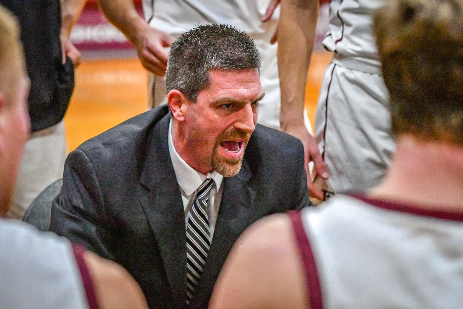 Evangel men's basketball coach Bert Capel gives instructions to his team during a timeout.
