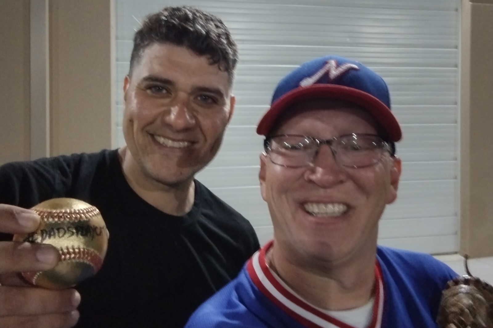 Author Ethan Bryan, right, with catch-playing partner Frank. Frank is holding a gold baseball labeled #DadsPlayCatch