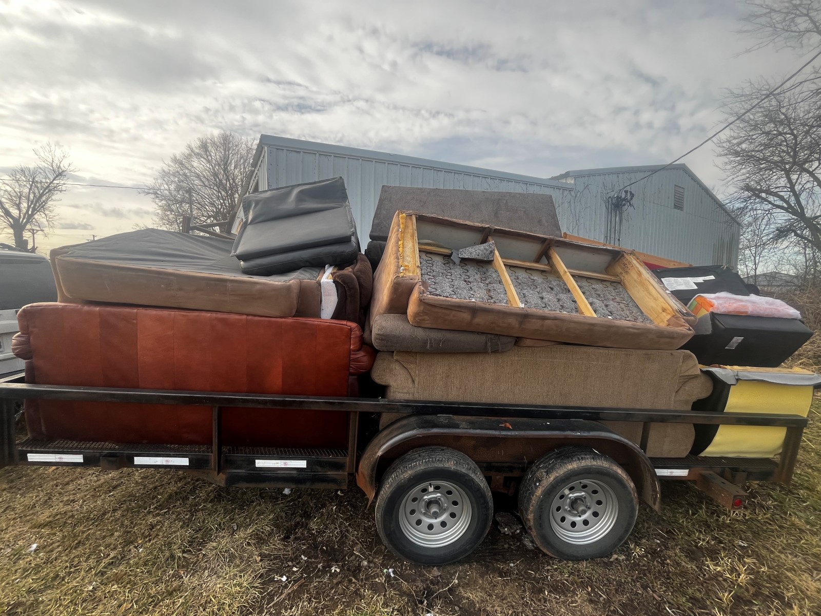 A flatbed trailer loaded up with old furniture.