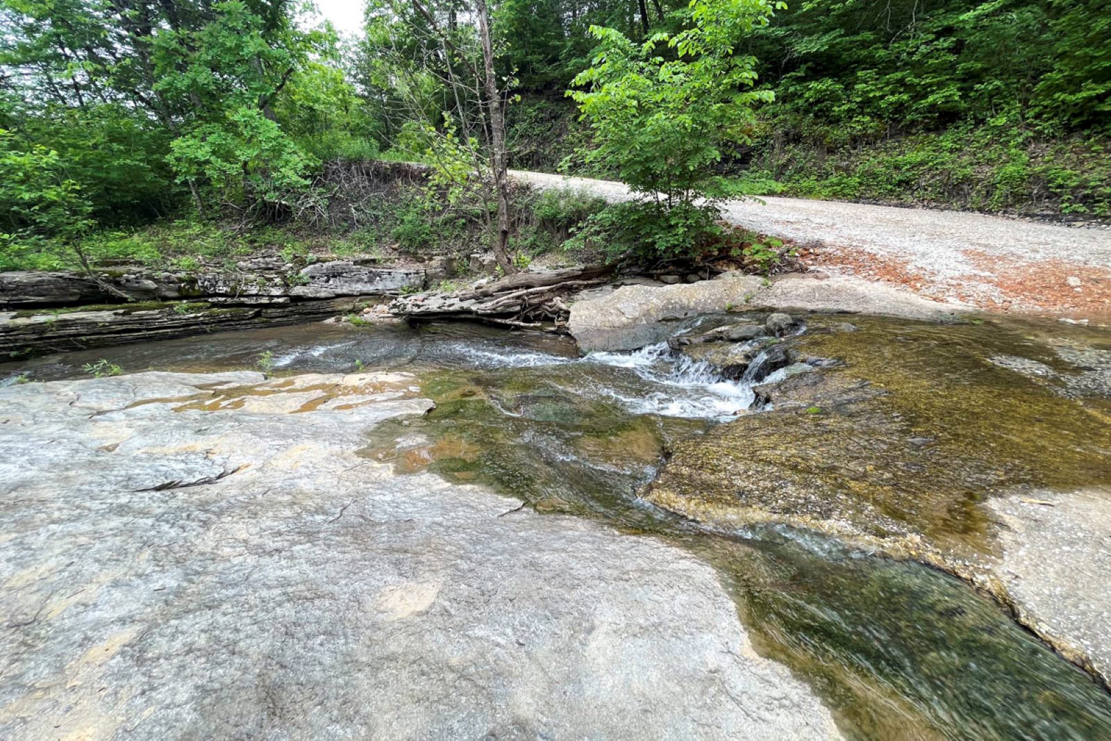To reach the Paige and Broadwater Hollow Falls trail, hikers walk down a road to cross this low-water bridge and spillway. (Photo by Sony Hocklander)