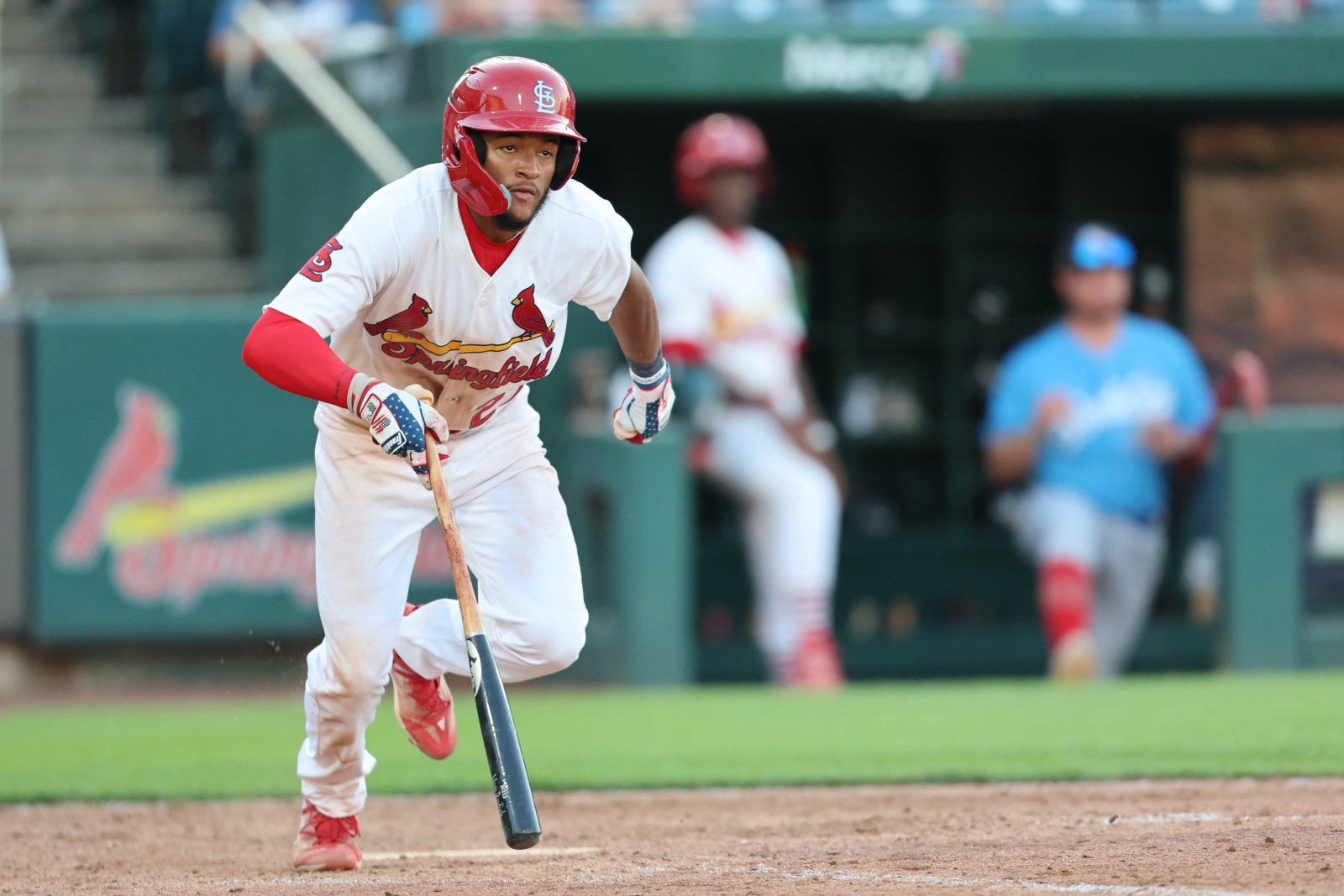 Victor Scott II, wearing a Springfield Cardinals uniform, runs to first base after hitting the ball during a game at Hammons Field in Springfield, Missouri.