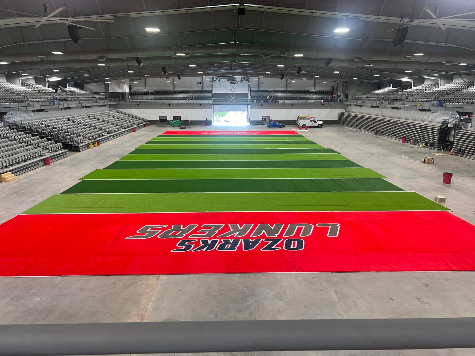 The field at Wilson Logistics Arena. The end zones are red with the words "Ozarks Lunkers" painted on them.