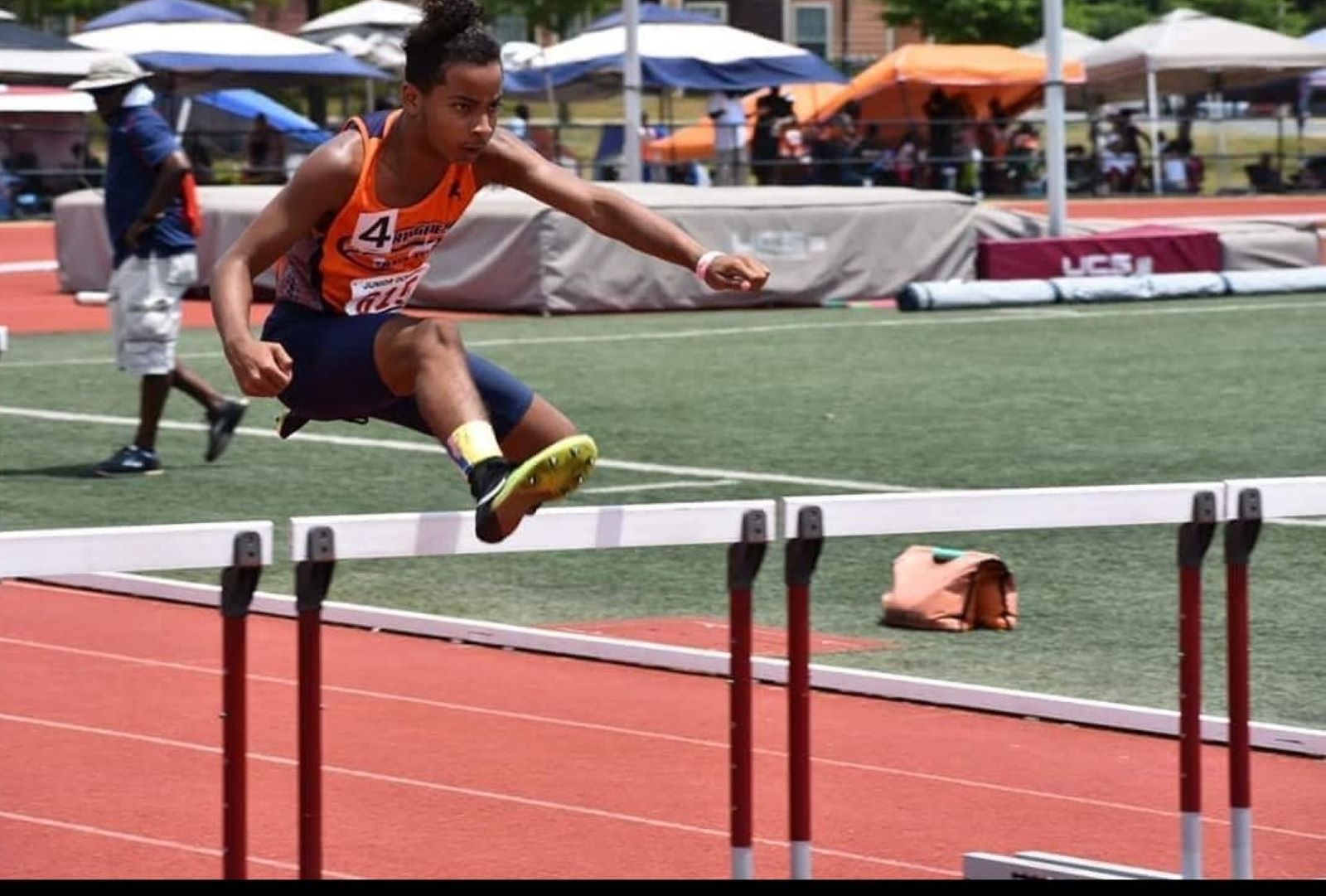 Deverin King jumps over a hurdle at a track meet in 2018