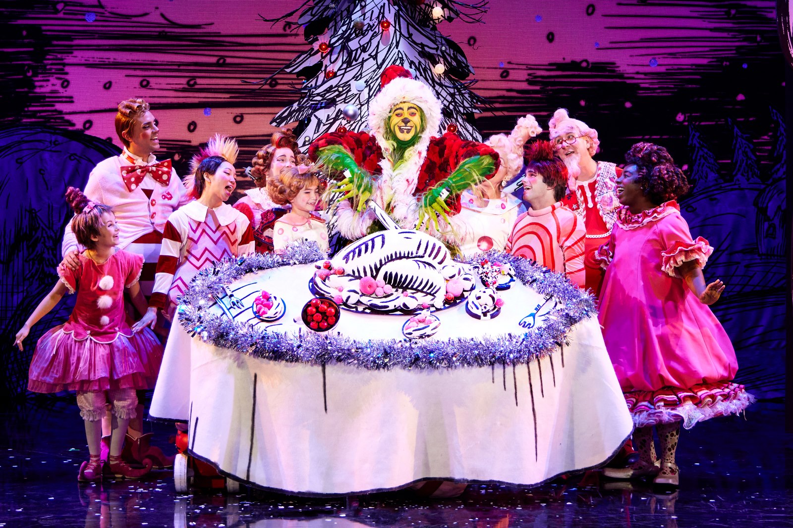 The cast of "Dr. Seuss' How the Grinch Stole Christmas! The Musical" performs a scene on stage.