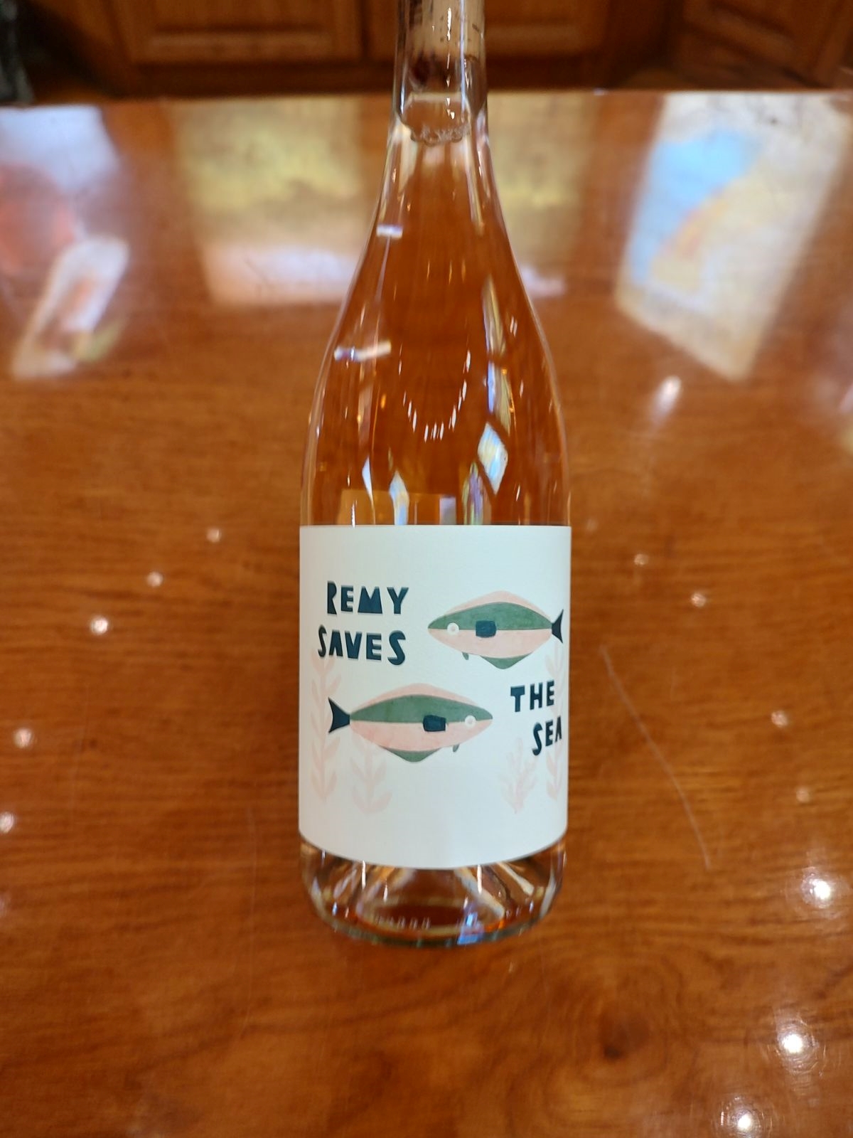 A bottle of Remy Saves the Sea rosé sits on a table